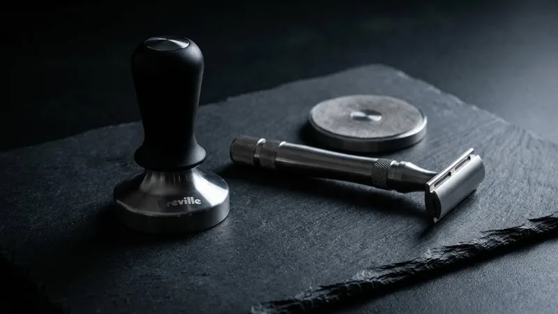 Breville accessories: tamper, razor tool, cleaning disc on dark slate