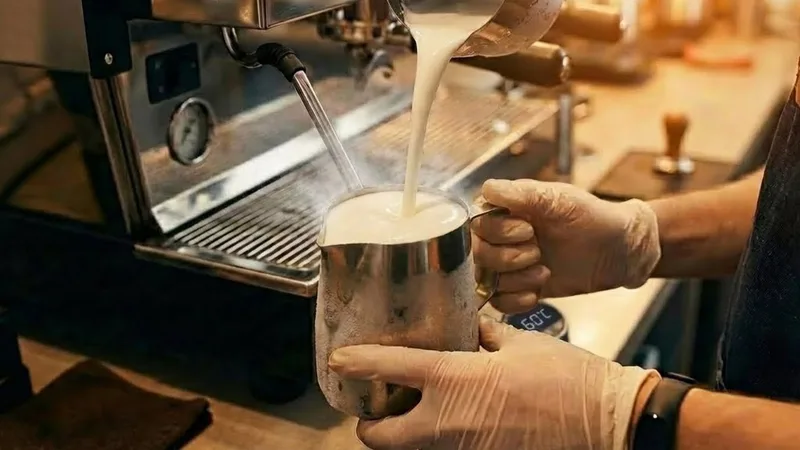 Beautiful, glossy microfoam in a pitcher with a digital display showing exactly 60°C, representing the peak sweetness and ideal temperature for latte art