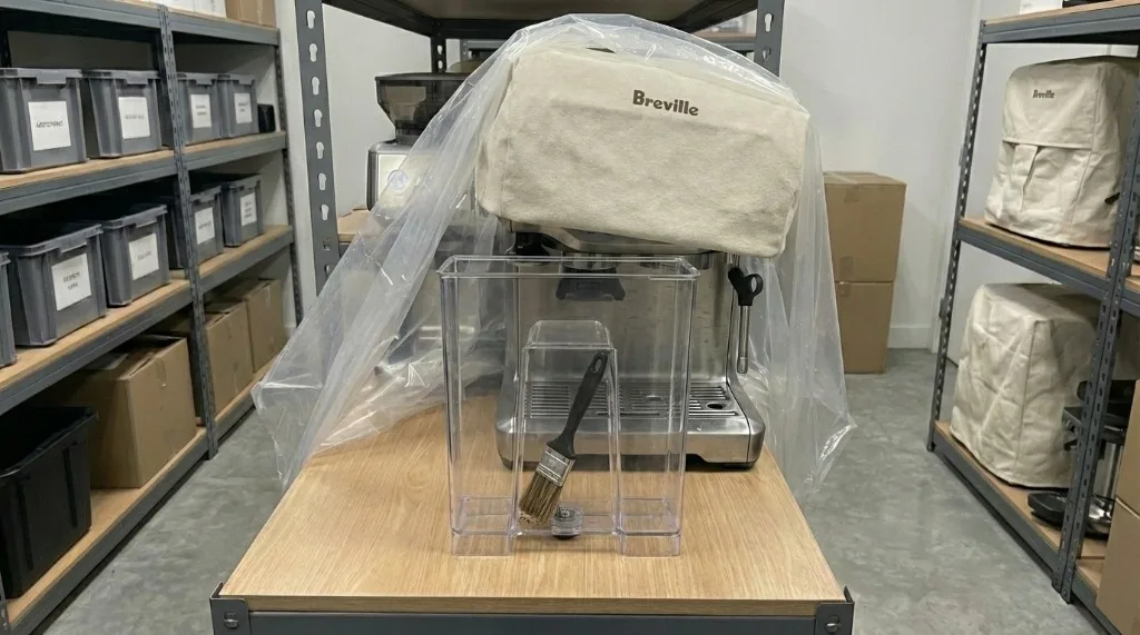 Using a cleaning brush to remove coffee grounds from the grinder hopper